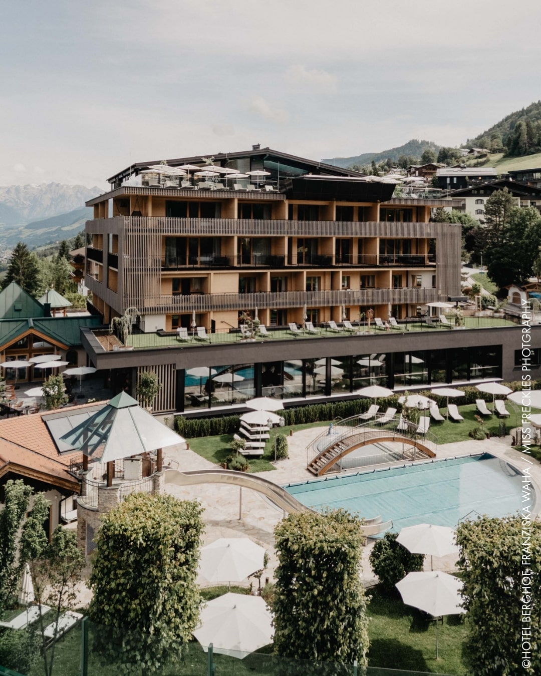 Hotel Berghof im Salzburger Land mit Außenpool und modernem Hotelgebäude vor Bergkulisse.