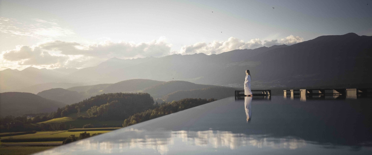 Infinity-Pool im Hotel Winkler in Südtirol mit Panoramablick auf die Dolomiten und die umliegende Berglandschaft.