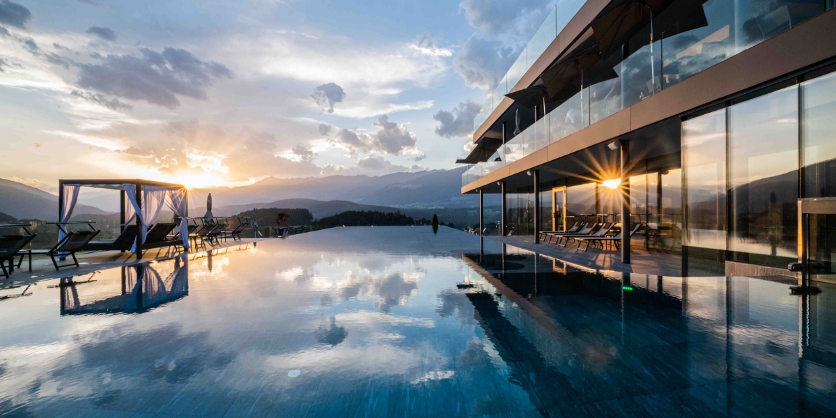 Infinity Pool des Hotel Winkler am Kronplatz bei Sonnenuntergang mit Blick auf die Dolomiten.